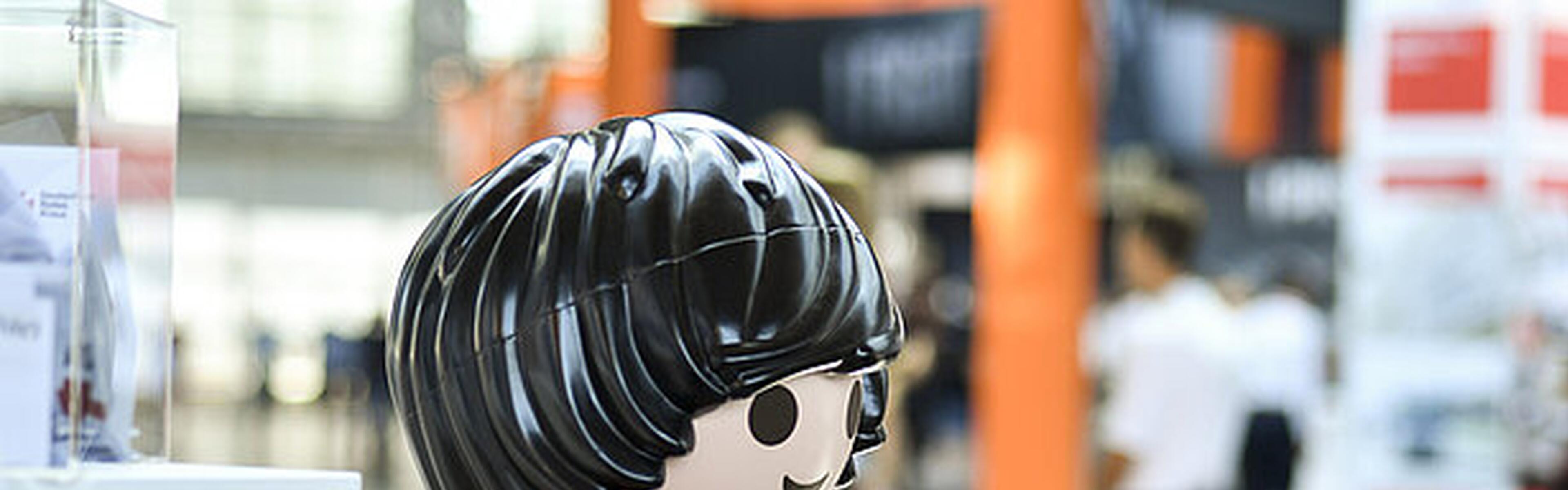 Playmobilfigur mit schwarzen Haaren und einer roten Jacke.